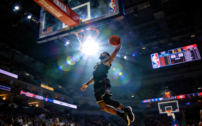 篮球直播画面 - NBA赛场球员飞跃扣篮，灯光聚焦